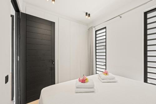 a bedroom with a white bed with towels on it at Ocean View Apartment 384 Blue Bay in Dorp Sint Michiel