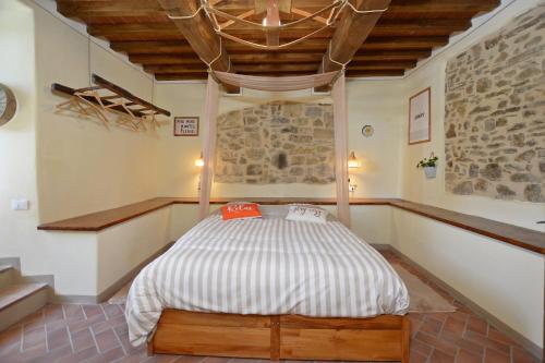 a bedroom with a bed in a room with a stone wall at Dimora Belfiore - Happy Rentals in Capolona