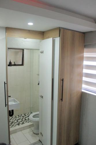 a bathroom with a toilet and a sink and a door at Viva Guest House in Trevallyn