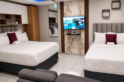 a hotel room with two beds and a tv at Viva Guest House in Trevallyn