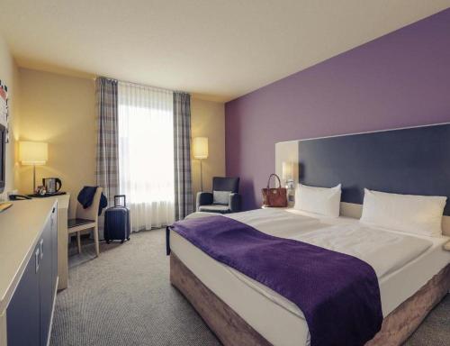 a bedroom with a large bed and a purple wall at Sunday Hotel Berlin City West in Berlin