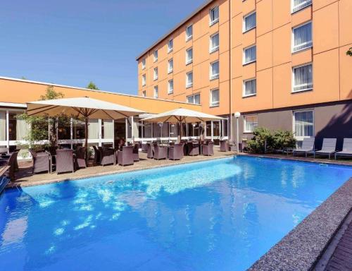 a large swimming pool in front of a hotel at Sunday Hotel Berlin City West in Berlin