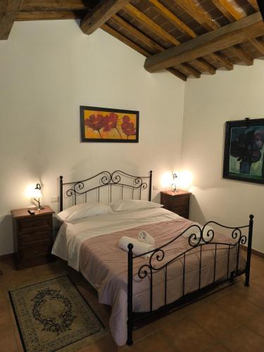 a bedroom with a large bed with two night stands at BUONUMORE-la QUIETE in Acquapendente