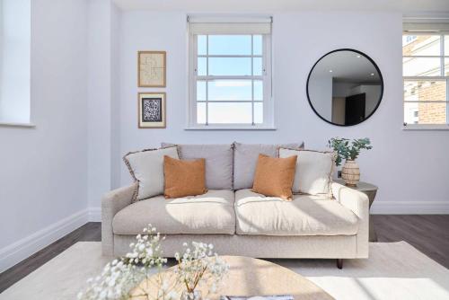 a living room with a couch and a mirror at Second Storey at Kew in Kew Bridge