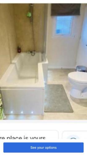 a bathroom with a white tub and a toilet at Lakeside in Carrowmoreknock