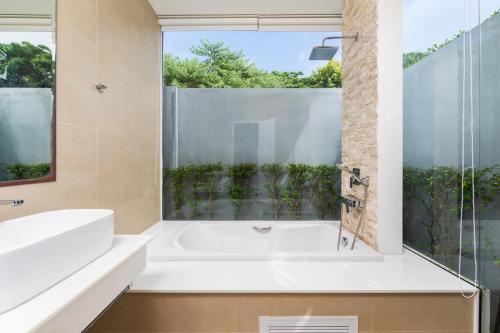 a bathroom with a white tub and a window at 5 Minutes to Naiharn Beach, Private, Quiet and Cozy in Nai Harn Beach