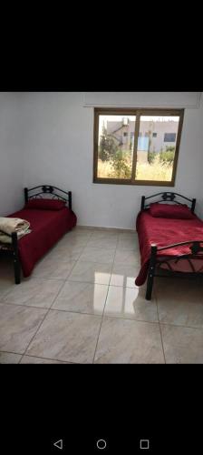 two beds in a room with a window at Albaraka-farm in Az Zarqa