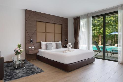a bedroom with a large bed and a pool at The BELL in Nai Yang Beach