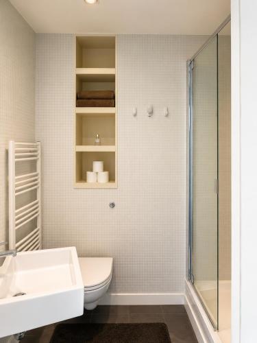 a bathroom with a toilet and a sink and a shower at Cozy City View Apartment in Birmingham