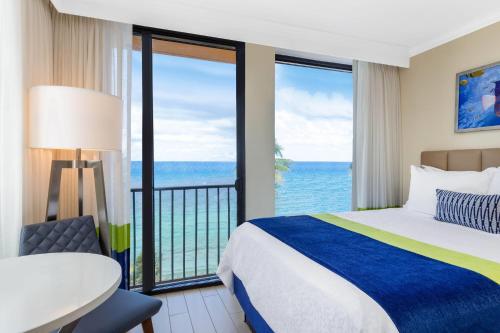 a bedroom with a bed and a view of the ocean at Wyndham Deerfield Beach Resort in Deerfield Beach