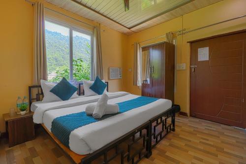 a large bed in a room with a large window at Prideinn Luxury Resort in Rishīkesh
