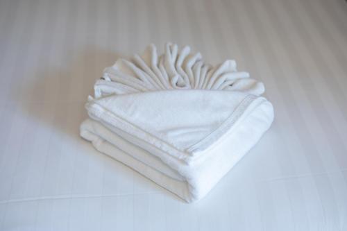 a stack of white towels sitting on a table at The BELL in Nai Yang Beach