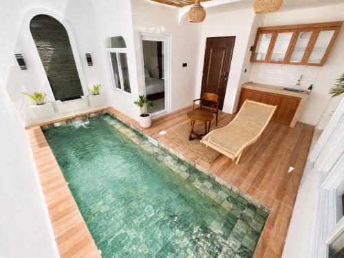 an indoor pool in a house with a table and a chair at Ayodhya Villa Patran in Kejayan