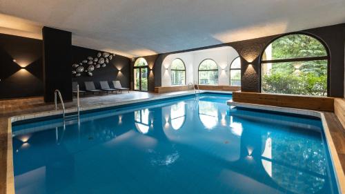 a large swimming pool with blue water in a house at Parkhotel Luise Bad Herrenalb in Bad Herrenalb
