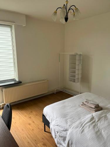 ein weißes Schlafzimmer mit einem Bett und einem Fenster in der Unterkunft Basic Business Accommodation in Geel