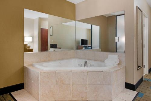 a large bathroom with a tub with a large mirror at Comfort Suites near MCAS Beaufort in Beaufort
