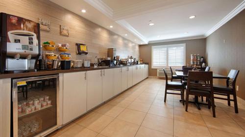 a restaurant with a counter and a table and chairs at Best Western Burbank Airport Inn in Los Angeles