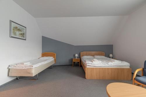a room with two beds and a table and chairs at Hotel Perła Bieszczadów Geovita in Czarna