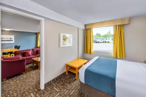 a hotel room with a bed and a couch at Crestwood Hotel in Hinton