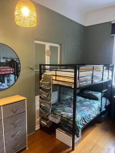 a room with two bunk beds and a mirror at Dreamtime Hostel in Cairns