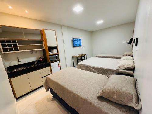 a small bedroom with two beds and a sink at Loft Hage in Belém