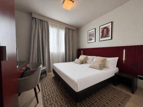 a hotel room with a large bed and a desk at Hotel Fiera Rimini in Rimini