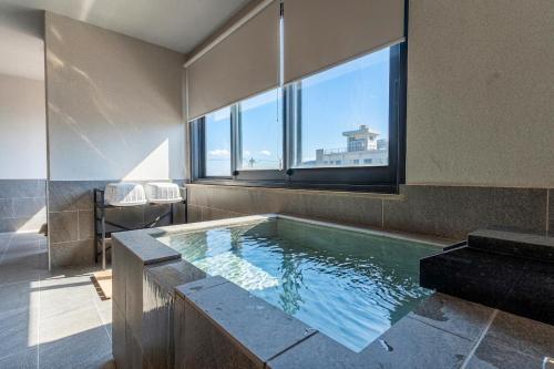 a large bath tub with a window in a bathroom at SEVEN SEAS HOTEL ITO (セブンシーズホテル） in Ito
