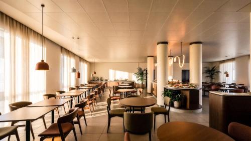 a restaurant with tables and chairs and a bar at Hotel Fiera Rimini in Rimini