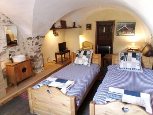 two beds in a room with a stone wall at le logis des Sieyes in Crévoux