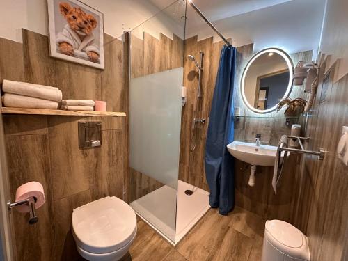 a bathroom with a toilet and a sink and a mirror at Mauguio Center Hôtel in Mauguio