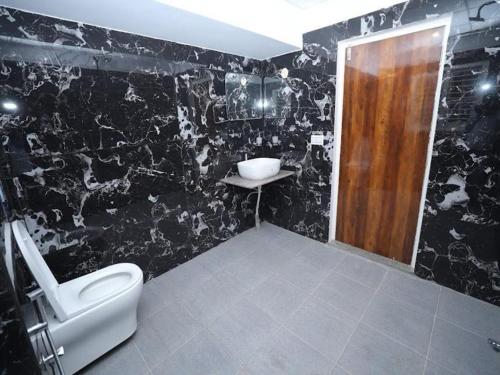 a black and white bathroom with a toilet and a sink at AMV Airport Residency in Bangalore