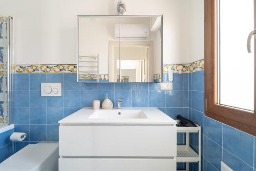 a bathroom with a white sink and a mirror at Tia Maria - Tradizione e Autenticità in Ploaghe
