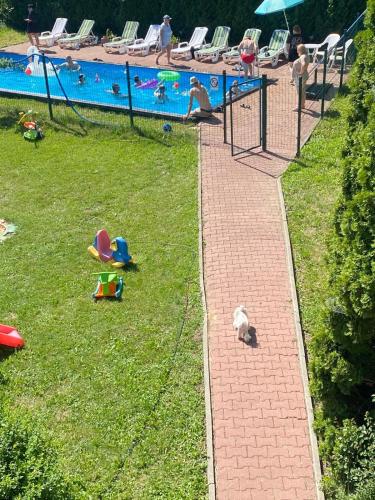 a group of children playing in the grass near a pool at Dom lub apartamenty z widokiem na góry Wichrowe Wzgórza z basenem Brenna in Ustroń