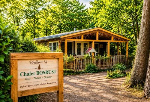 a cottage in the woods with a sign in front of it at Chalet Bosrust met serre & privéparking Natuur nabij Maastricht in Lanaken