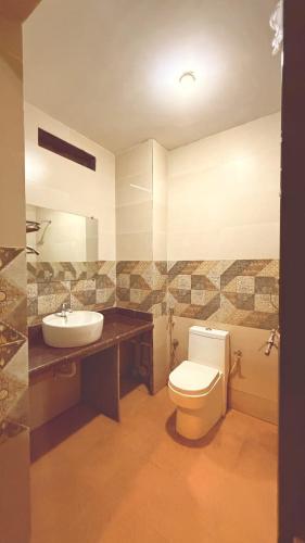 a bathroom with a white toilet and a sink at Hotel Simba by Hakuna in Arambol