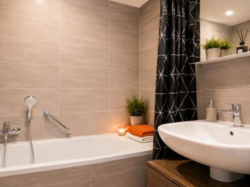 a bathroom with a white tub and a sink at Moscow Areal Suite in Baden-Baden