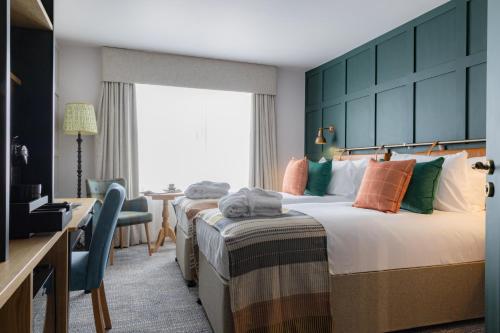 a hotel room with two beds and a television at Bernwood Park Hotel in Boarstall
