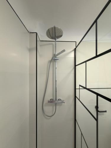 a shower with a shower head in a bathroom at Albergue -Hostel ManuelaINN in El Burgo de Osma