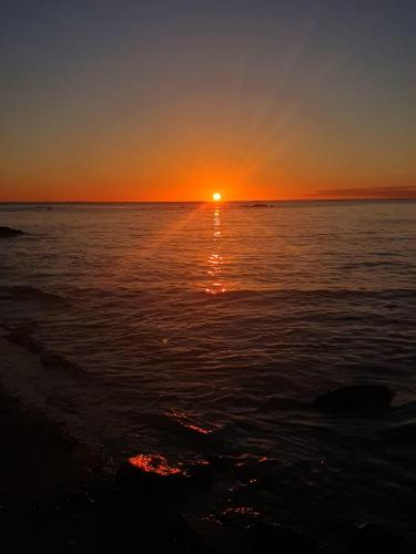 a sunset over a body of water with the sun setting at Hyacinth Golf& Sea in Grand-Baie
