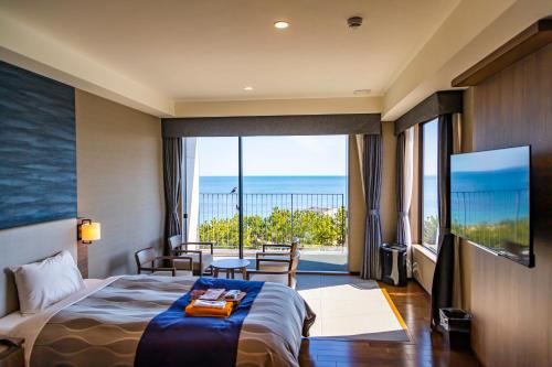a hotel room with a bed and a view of the ocean at REX HOTEL Beppu in Beppu