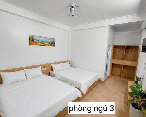 two beds in a small room with white walls at Mùi Oanh Homestay sát biển in Sầm Sơn