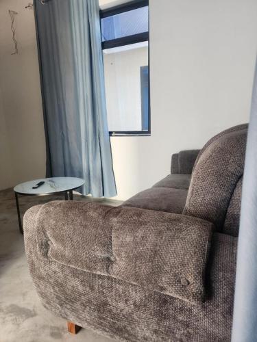 a living room with a couch and a window at Blue Dhow Villas in Paje