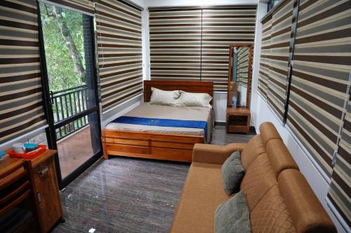 a small room with a bed and a couch at Kaivalyam Homestay in Wayanad