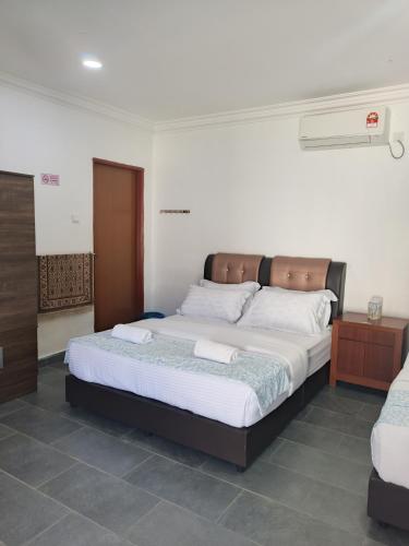 a bedroom with a large bed in a room at Aimers Lodge in Dungun