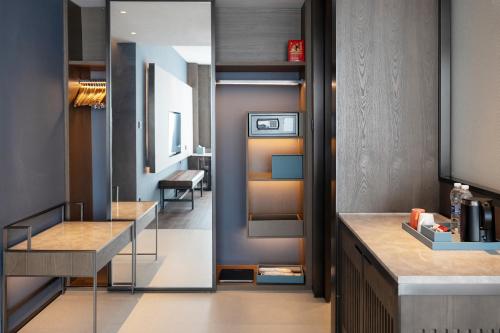 a kitchen with a counter and a dining room at Four Points by Sheraton Hefei, Qirui in Hefei