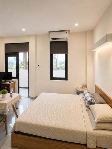a bedroom with a large bed and a living room at The F House in Danang