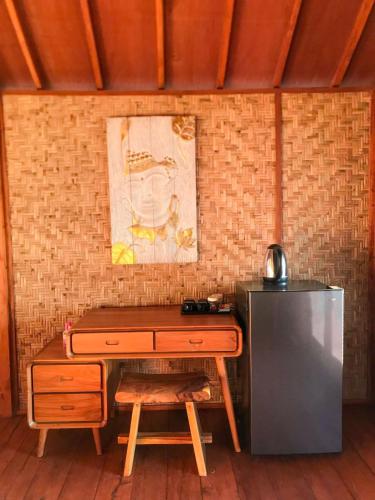a desk with a chair next to a refrigerator at Anorawi Supersuck Surf Accommodation in Maluk