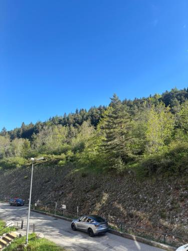 a car parked in a parking lot next to a hill at Studio le balcon pied des pistes in Villard-de-Lans
