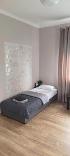 a bed in a room with a brick wall at Agroturystyka Kryjówka Nad Stawem in Kodeń