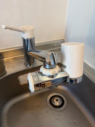 a silver sink with a cup on top of it at Fukuoka Tabiji Hostel 福岡旅路ゲストハウス in Fukuoka